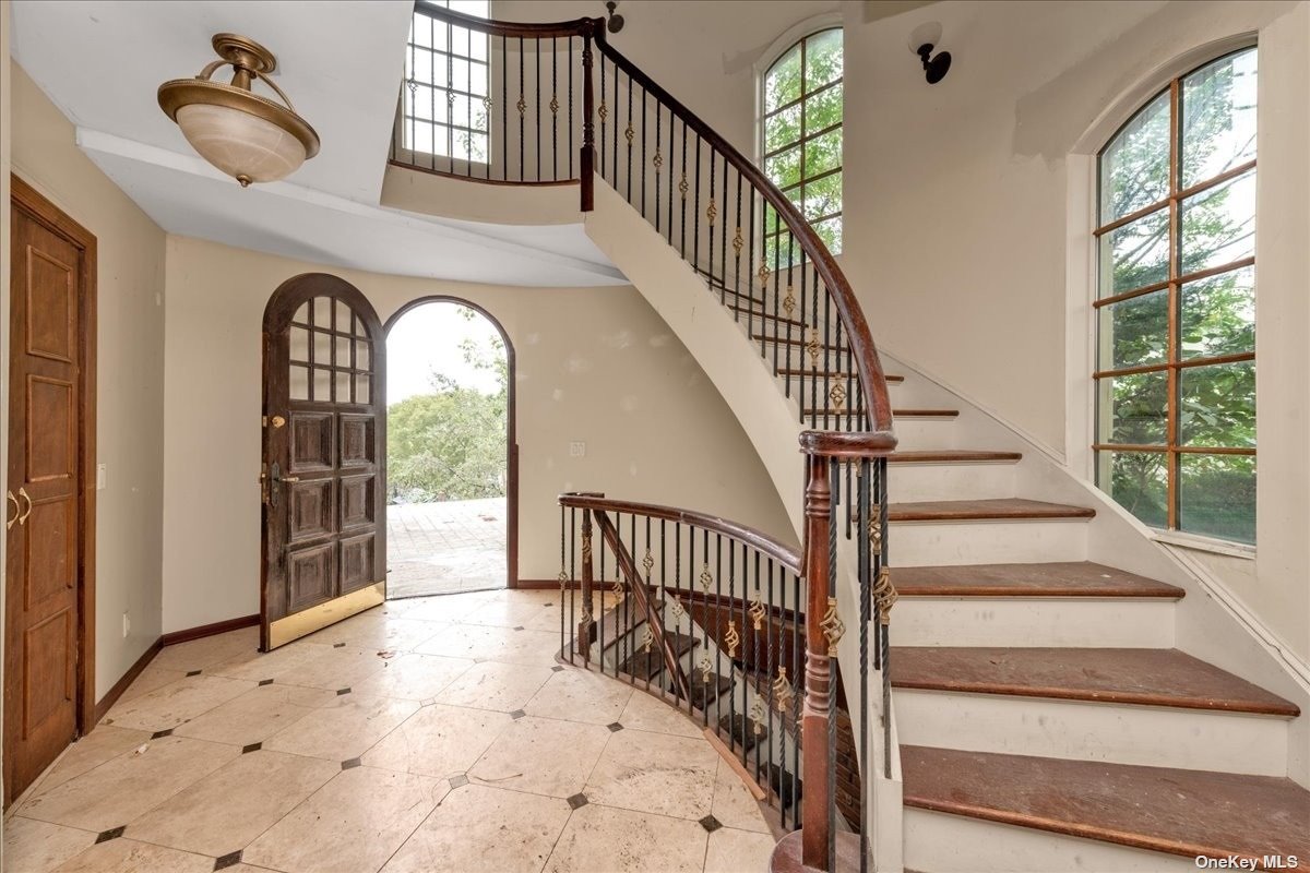 a view of staircase with wooden floor and a large window