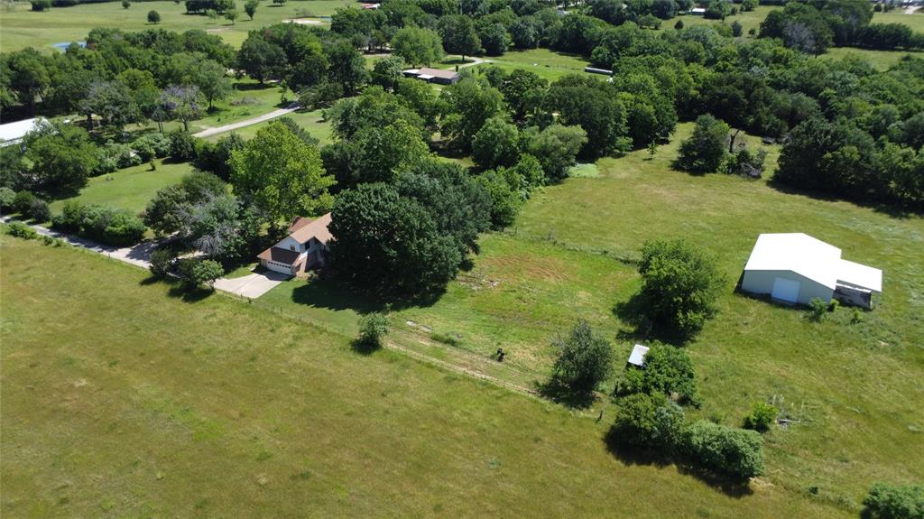 an aerial view of a house with a yard and lake view