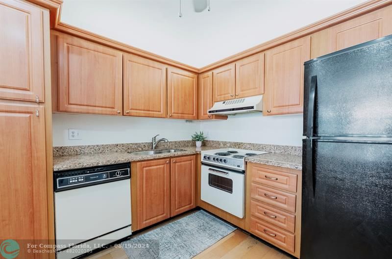 a kitchen with stainless steel appliances granite countertop a stove a refrigerator and a cabinets