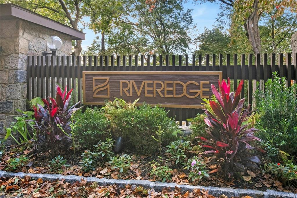 a view of sign board with flower in a yard