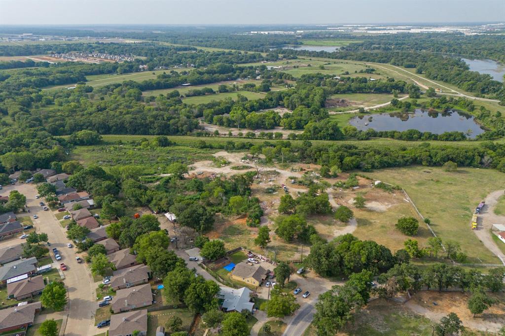 an aerial view of residential houses with outdoor space and trees