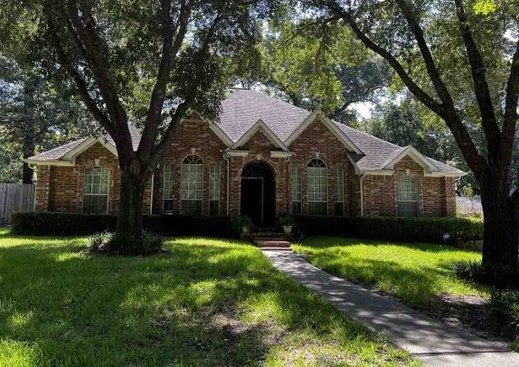 a front view of a house with yard and green space