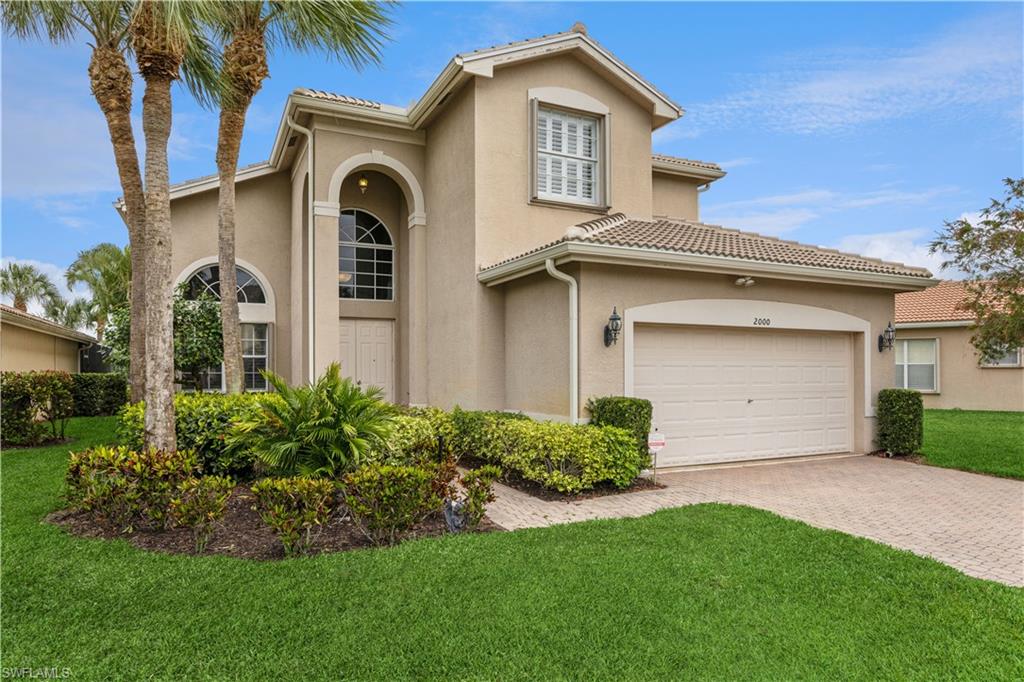 a front view of a house with a yard and garage