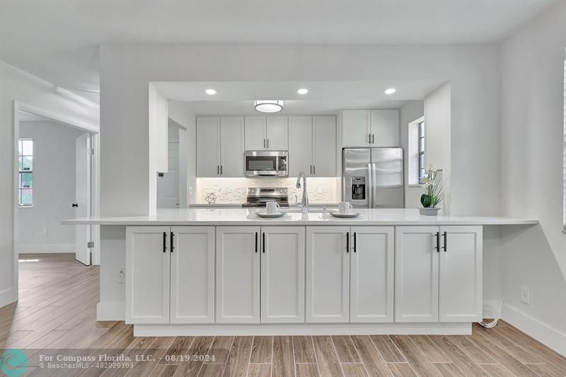 a kitchen with white cabinets stainless steel appliances and sink