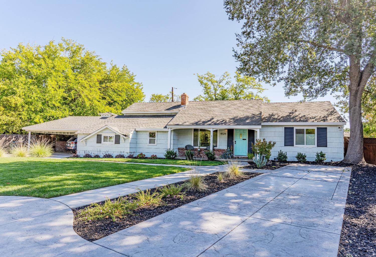 a front view of a house with a garden and trees