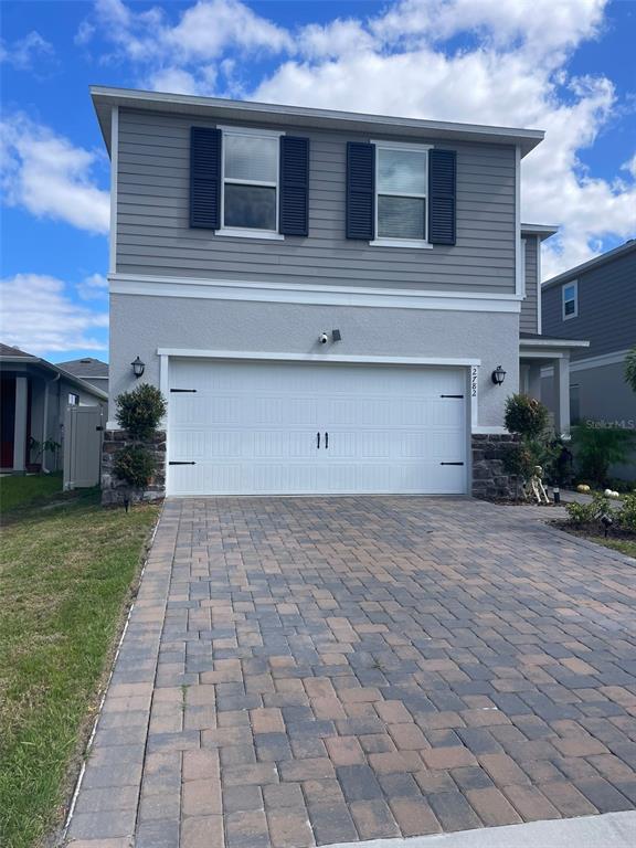 a front view of a house with a yard and garage