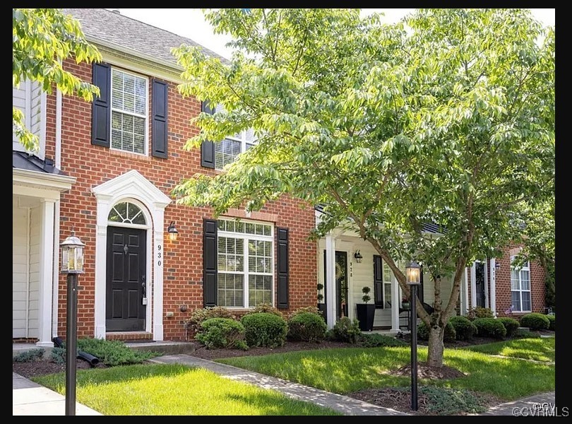 a front view of a house with yard and green space