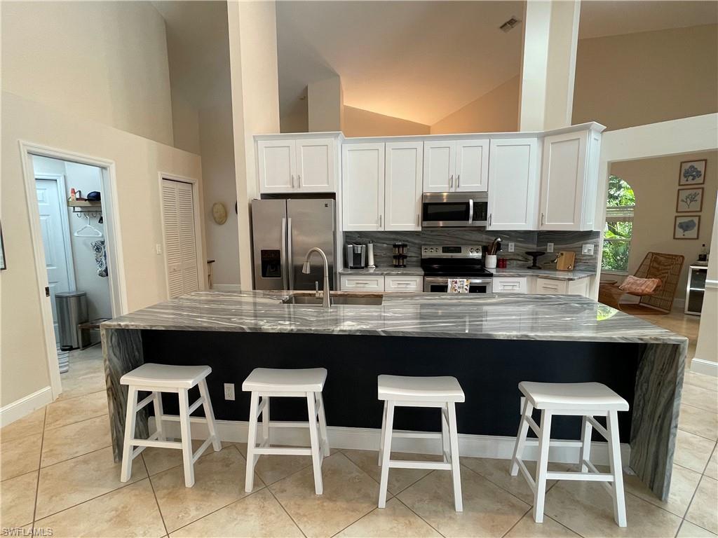 a kitchen with a dining table chairs and white cabinets