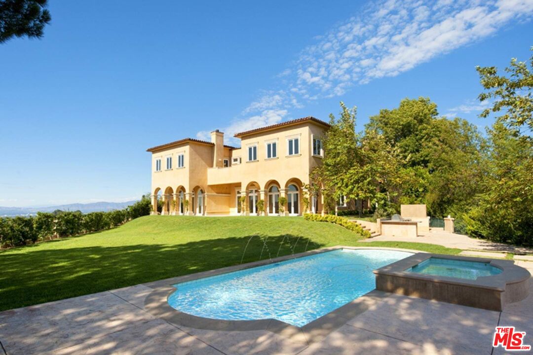 a view of a big house with a big yard and large trees