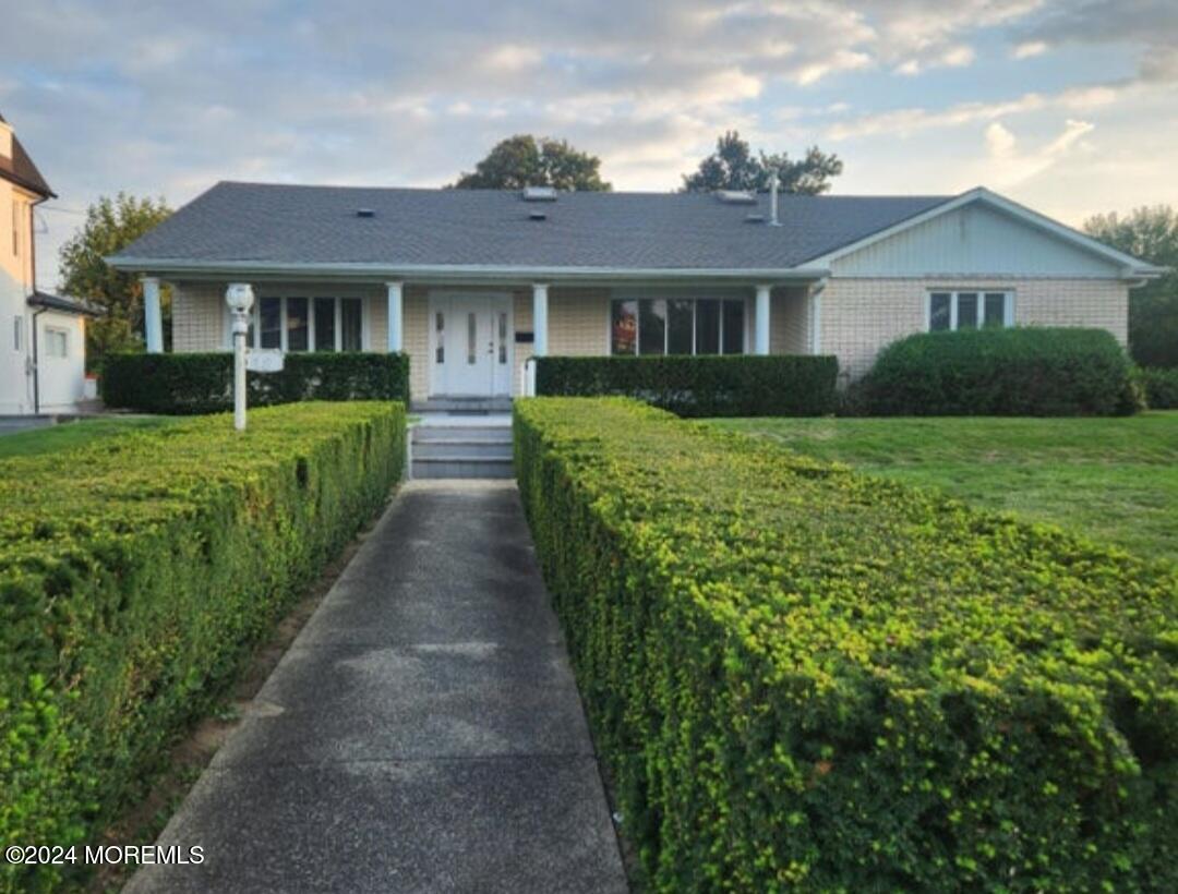 a front view of a house with yard and green space