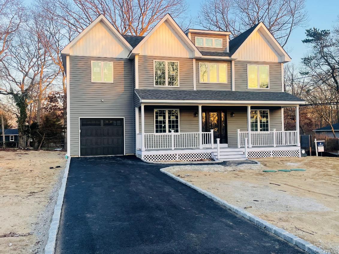 View of front of home with covered porch and a garage