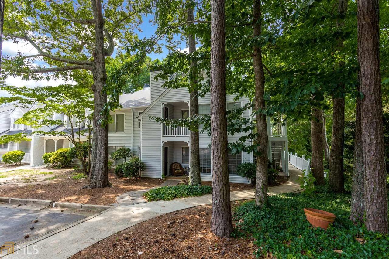 a view of a white house with a yard and tree s