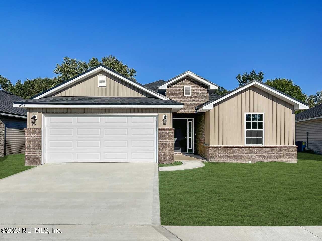 a front view of a house with a yard and garage