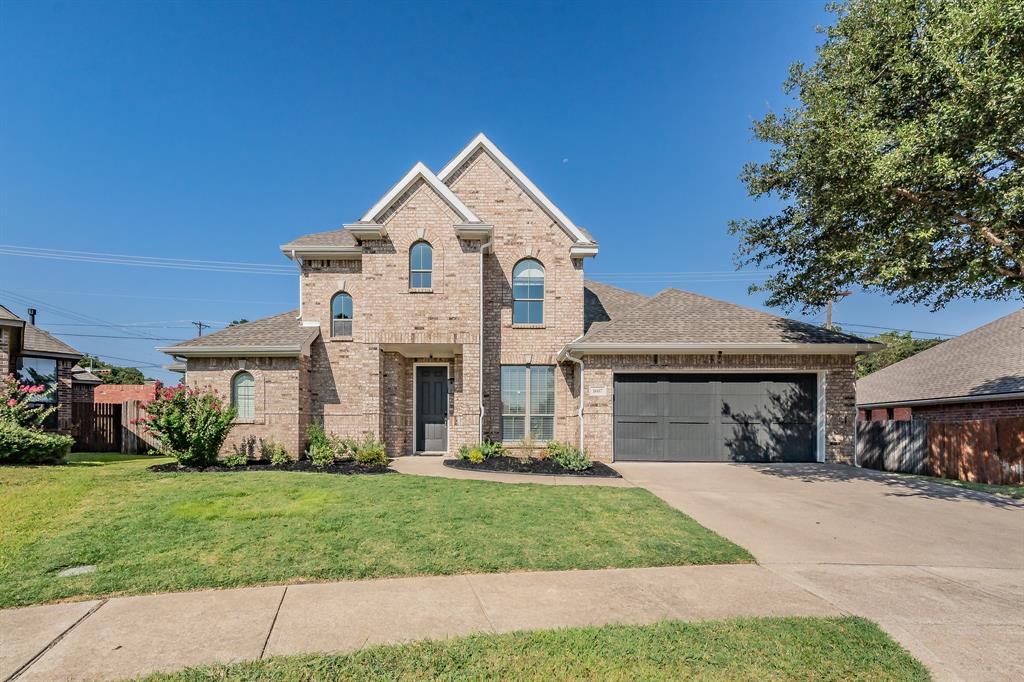 View of front of property with a garage and a front lawn