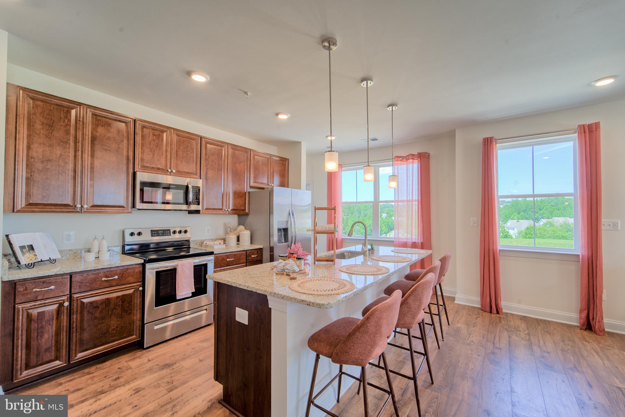 a kitchen with stainless steel appliances a stove a sink a refrigerator and wooden cabinets