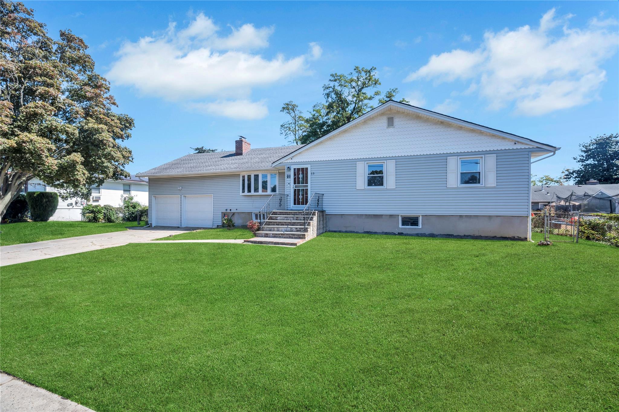 View of front facade featuring a front yard and a garage