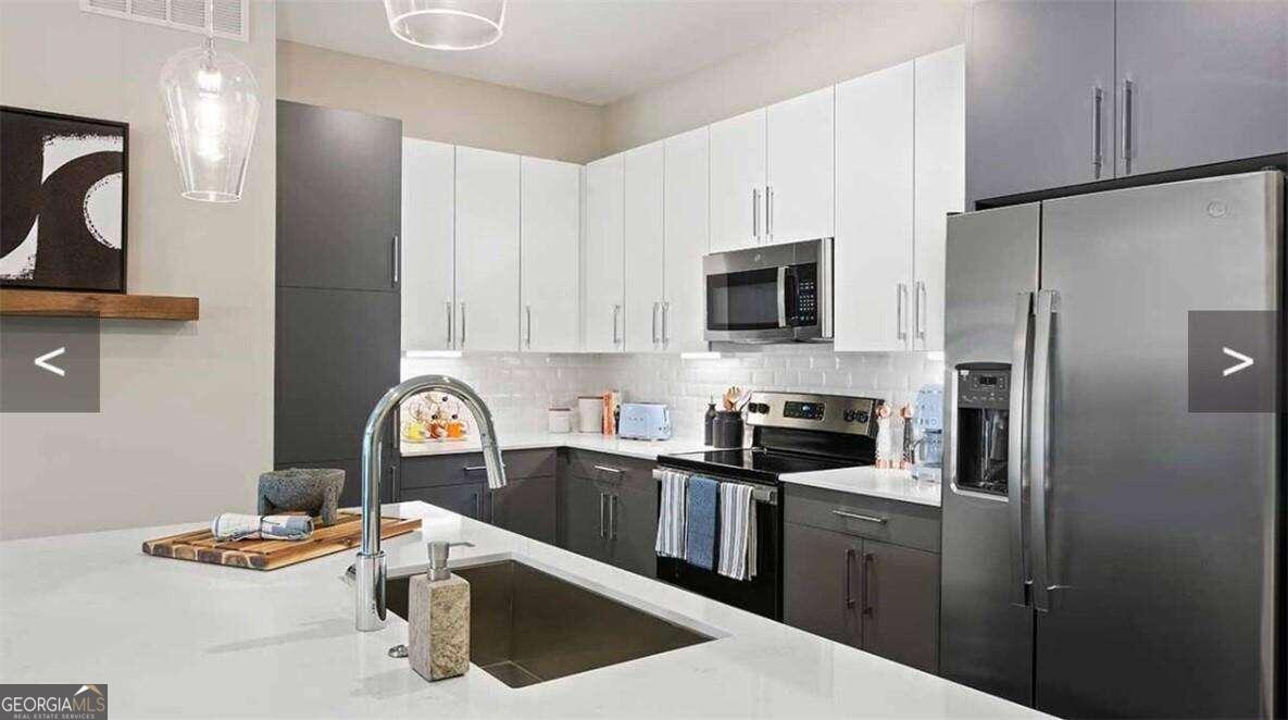 a kitchen with stainless steel appliances granite countertop a refrigerator sink and stove