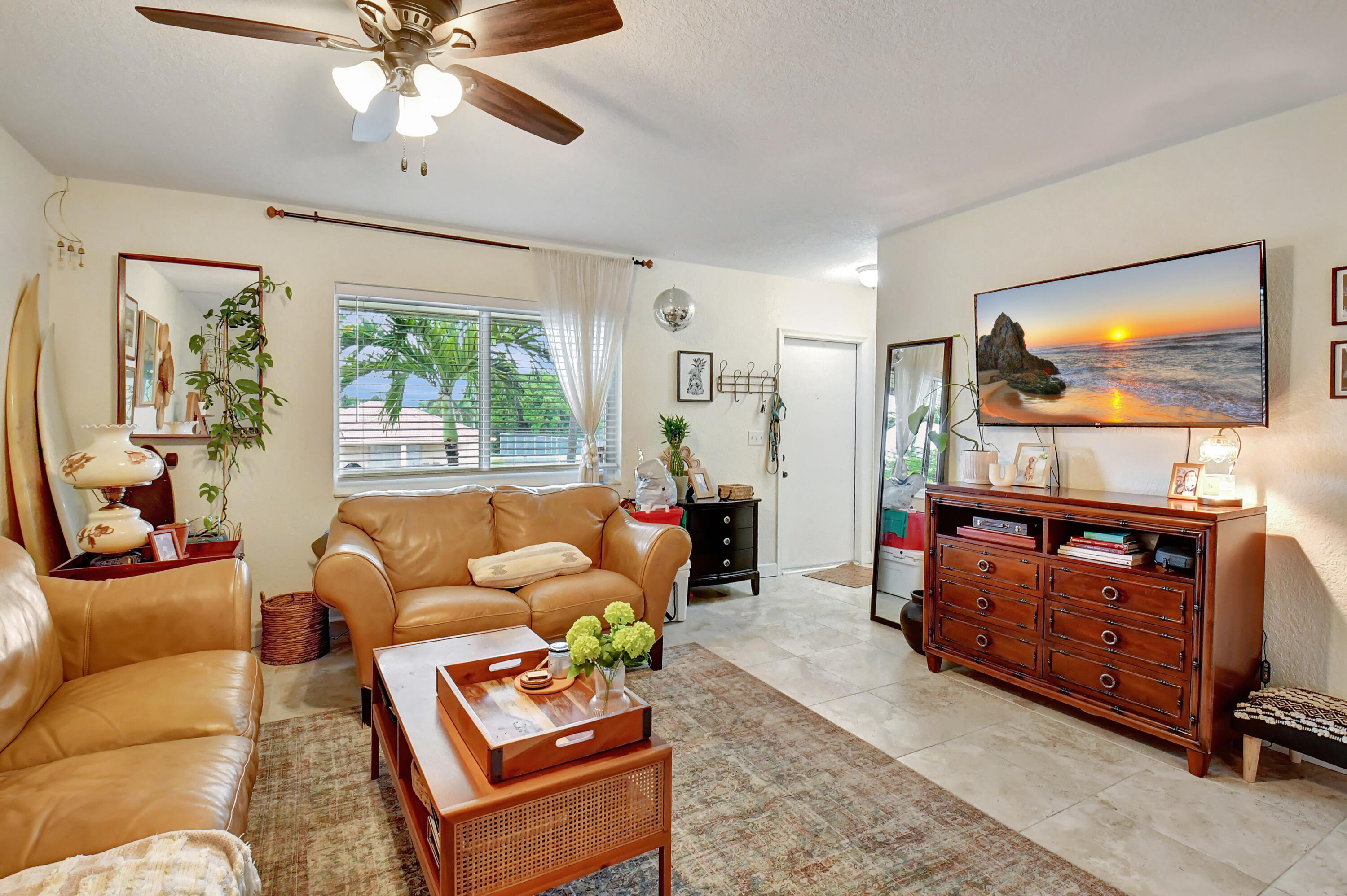 a living room with furniture a flat screen tv and a chandelier