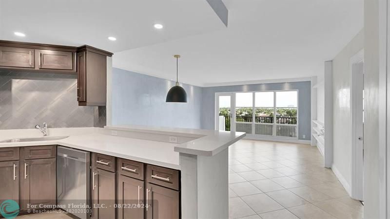 a kitchen with kitchen island a sink appliances and a large window