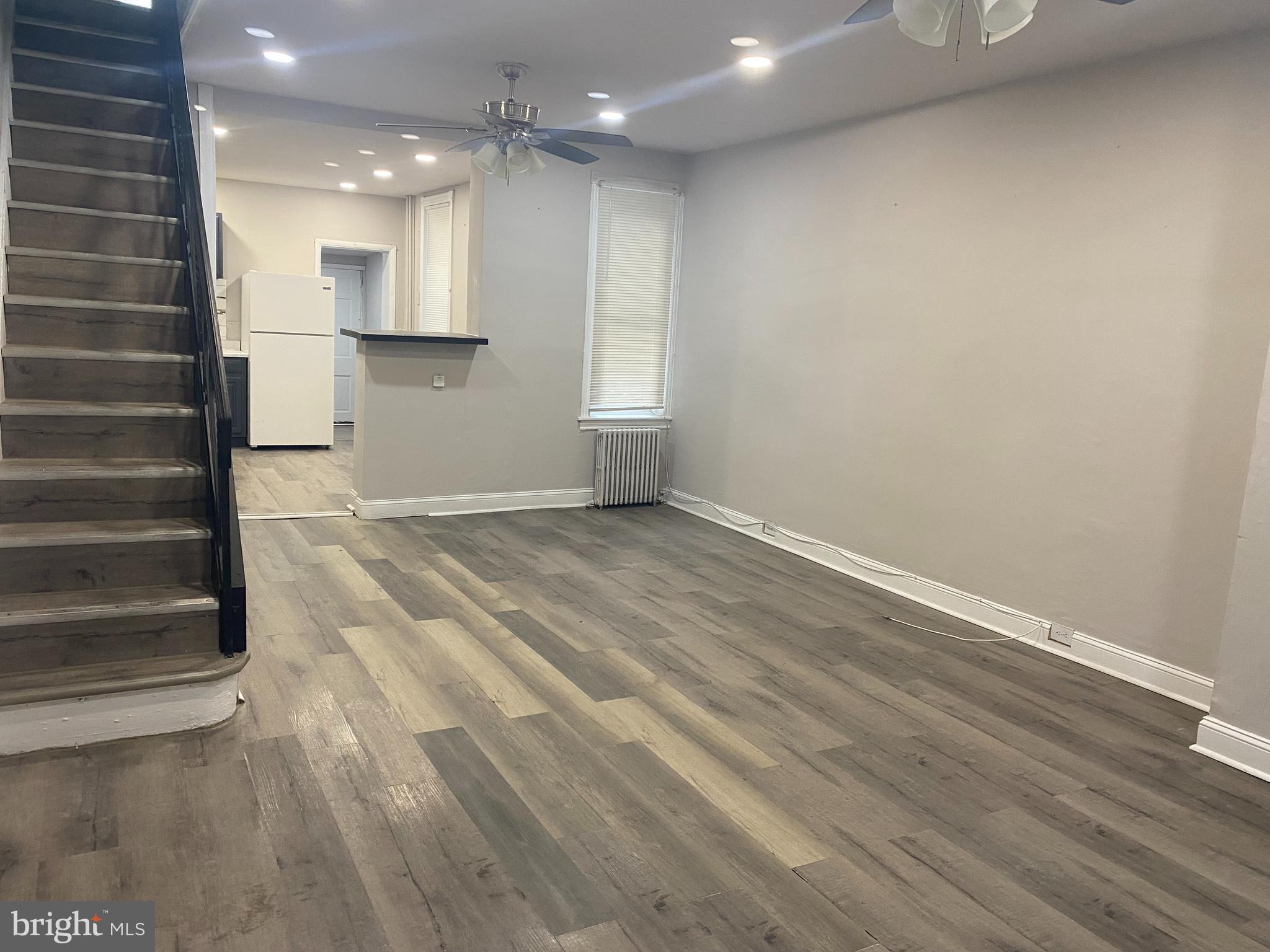 a view of empty room with kitchen and window