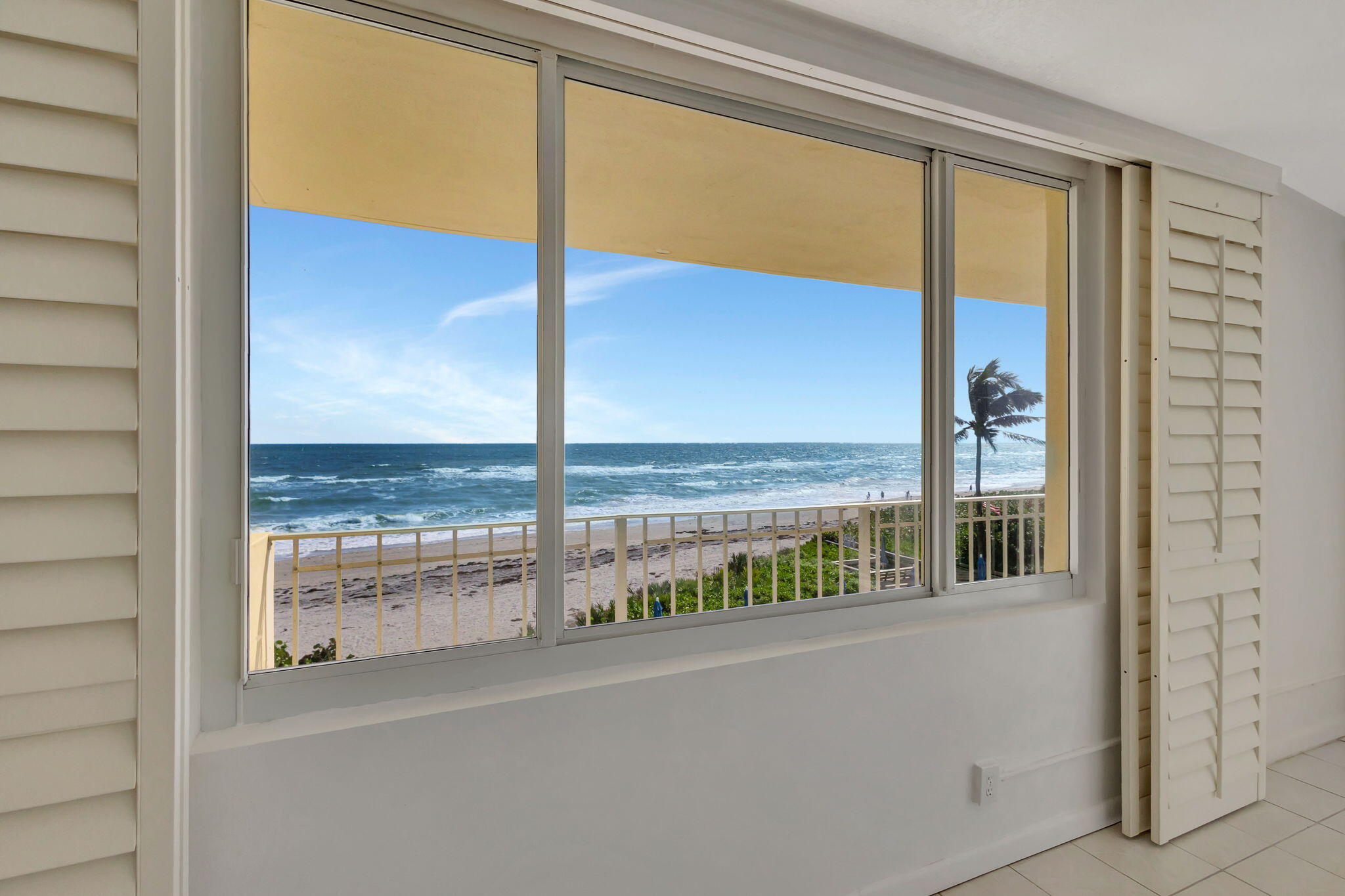 a view of a glass door with a balcony from a window