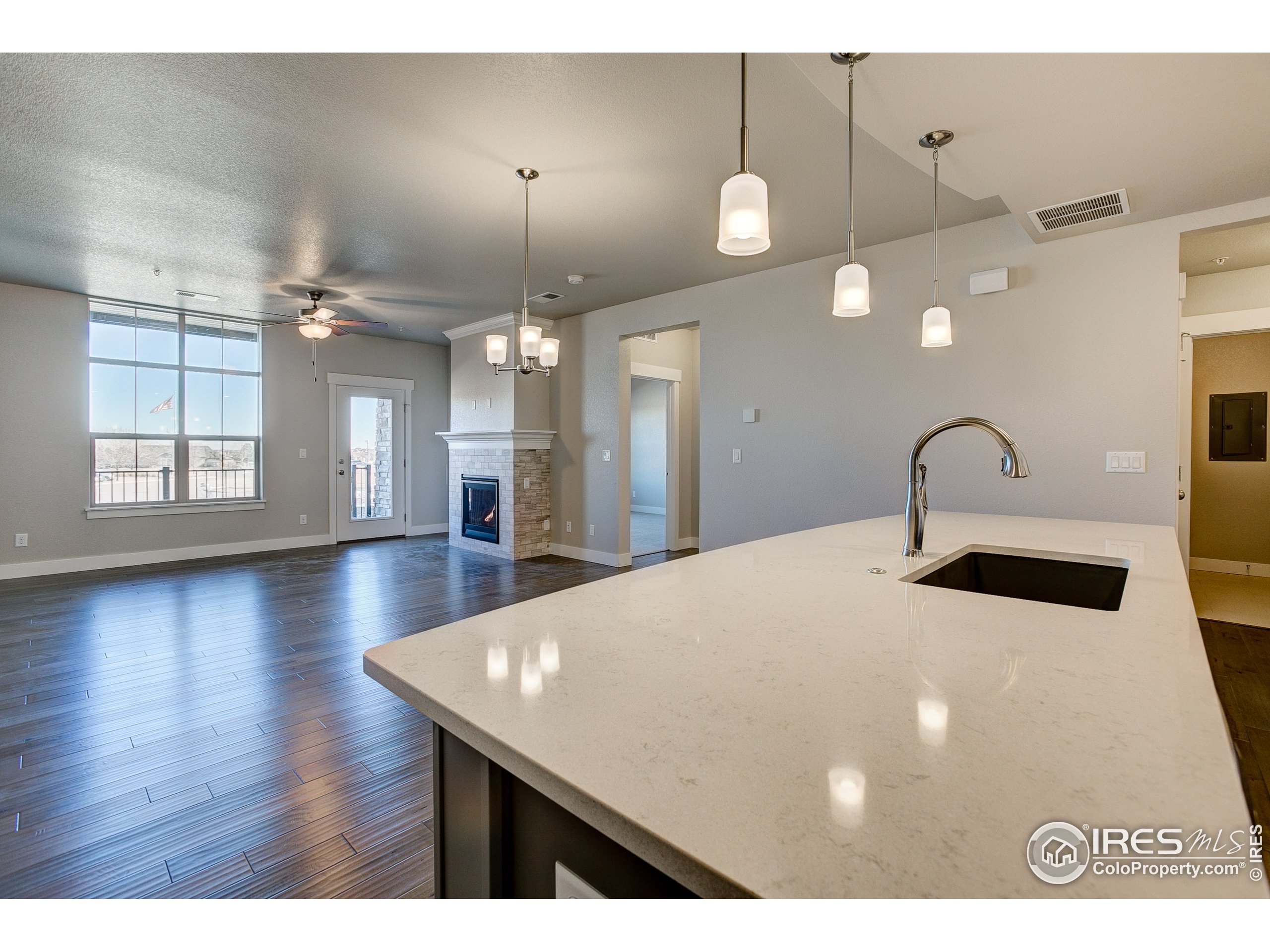 a kitchen with a sink chandelier and wooden floor