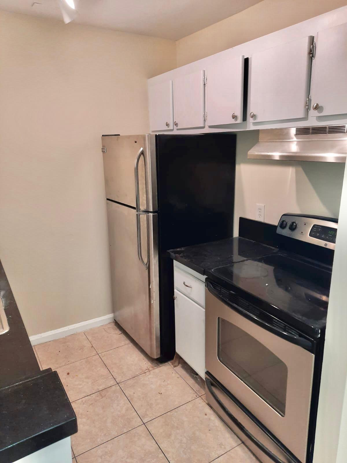 a kitchen with granite countertop a refrigerator and a stove