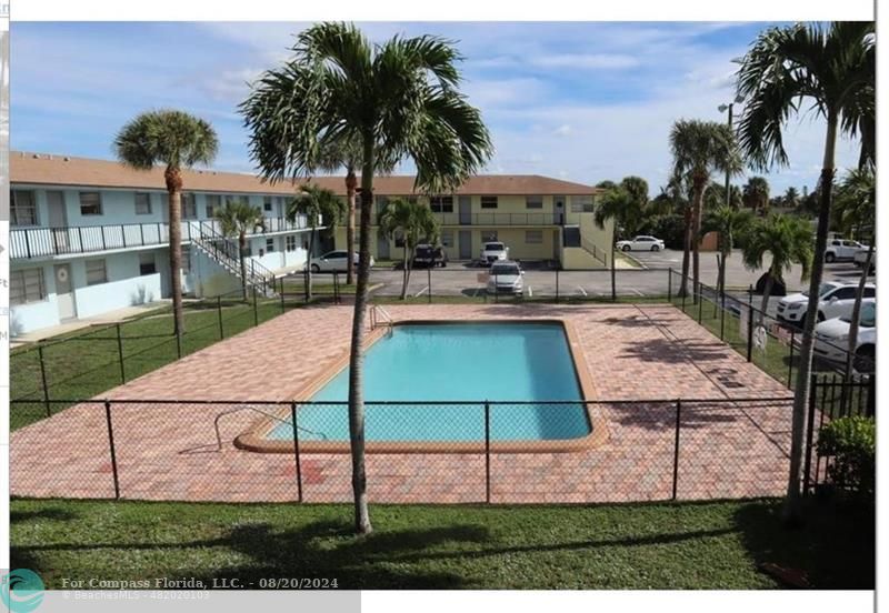 a view of a backyard with a patio and swimming pool