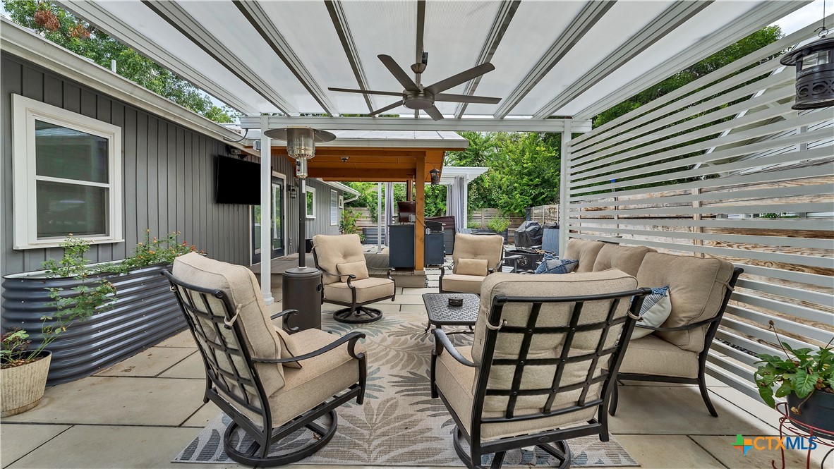 a view of patio with a table and chairs and a barbeque