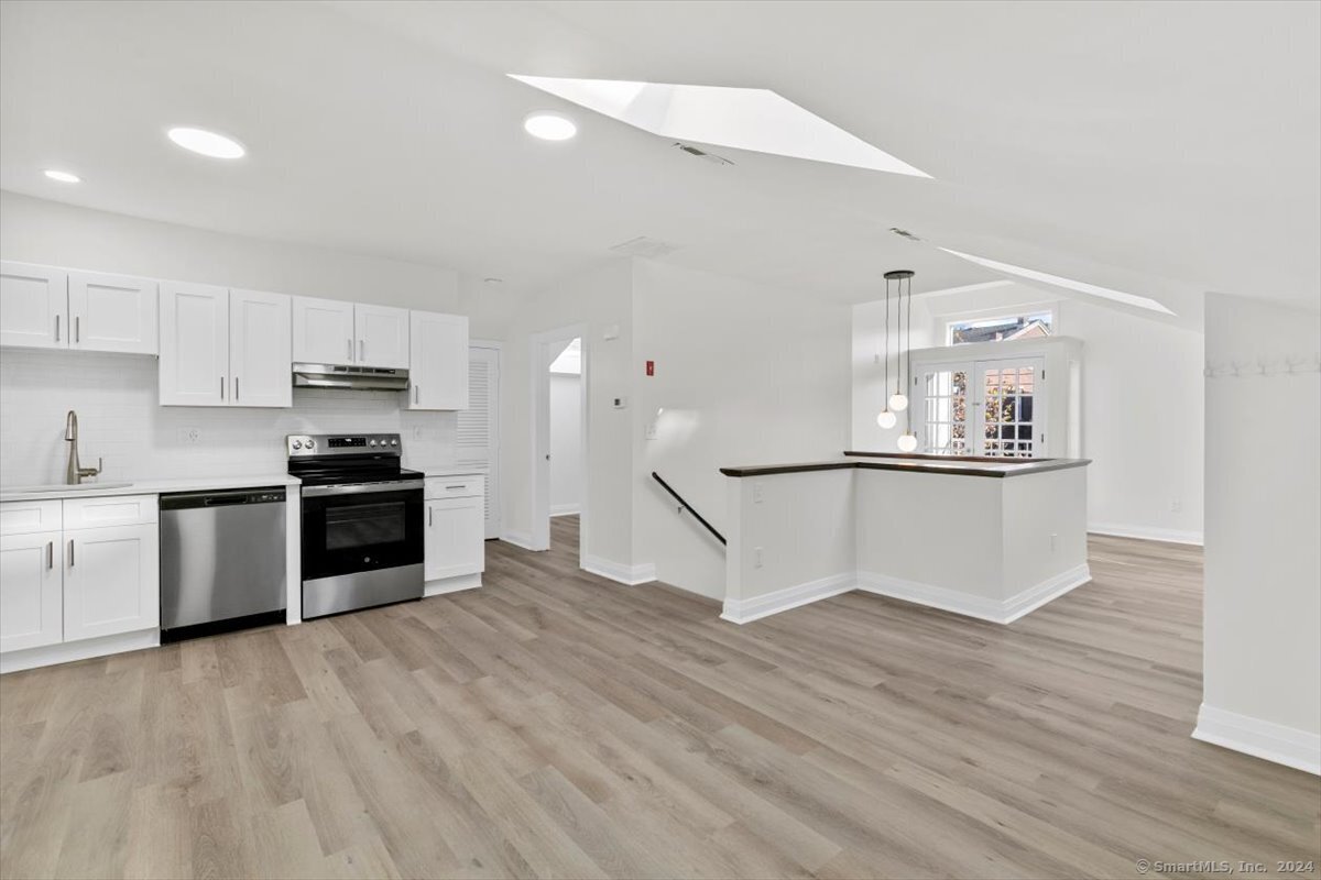 a kitchen with granite countertop a refrigerator and a stove top oven