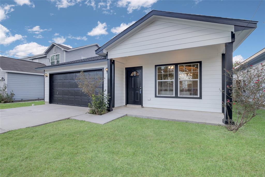 front view of a house with a yard and garage