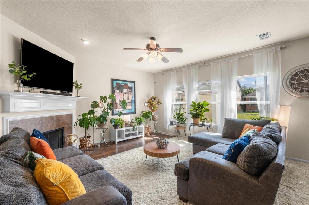 a living room with furniture a fireplace and a flat screen tv