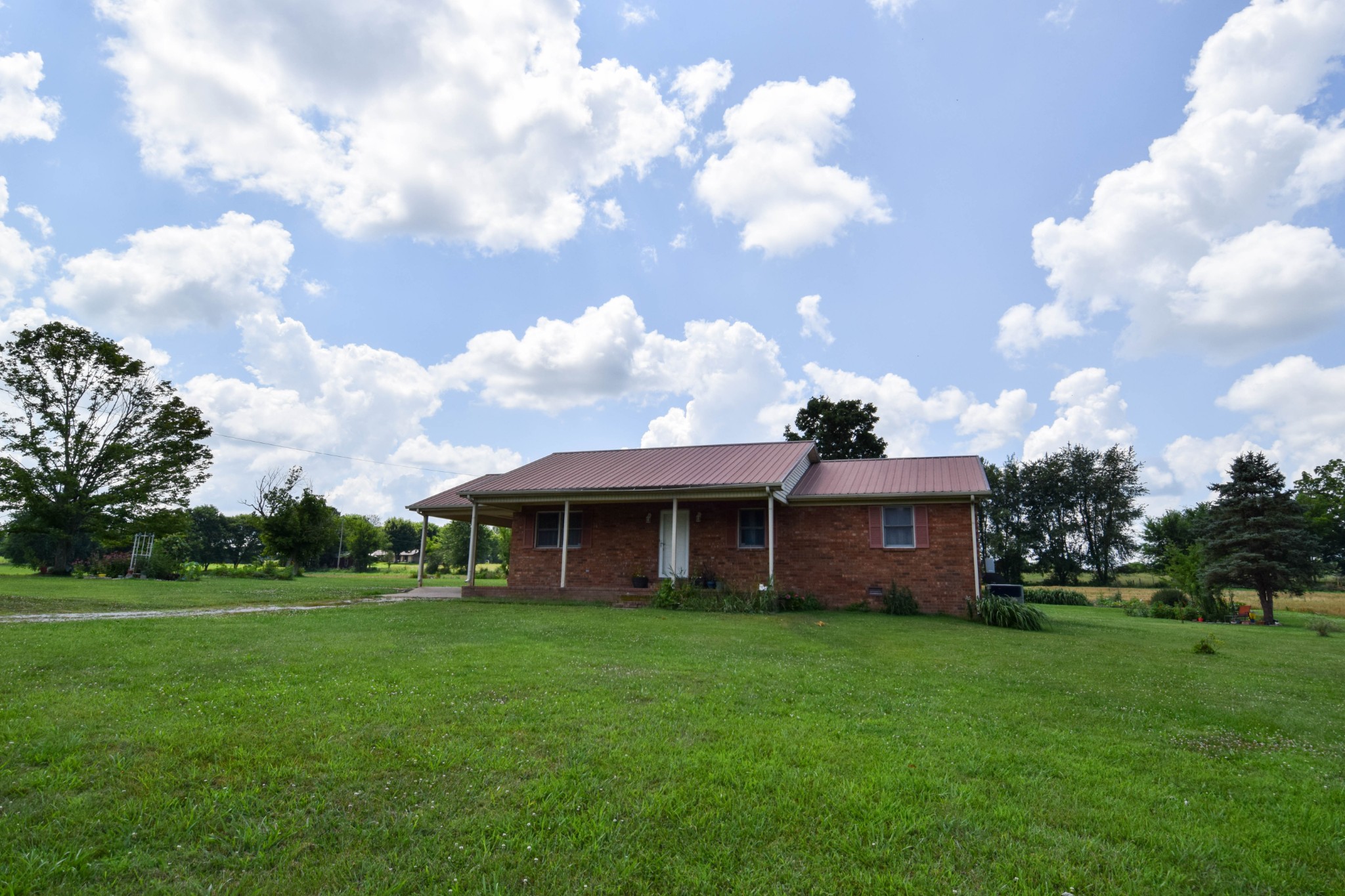 a view of a house with a big yard and a large tree