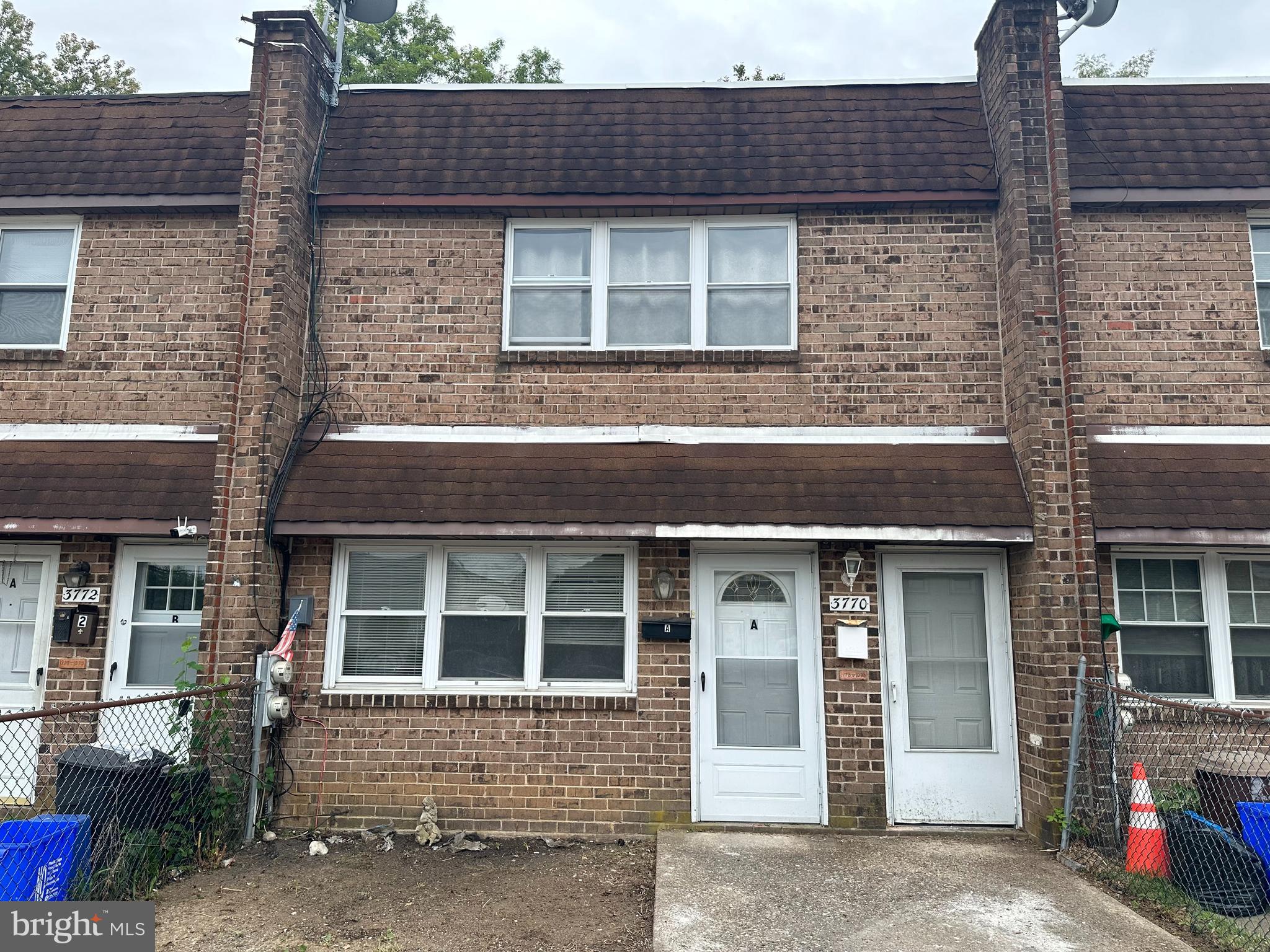 front view of a brick house with a small yard