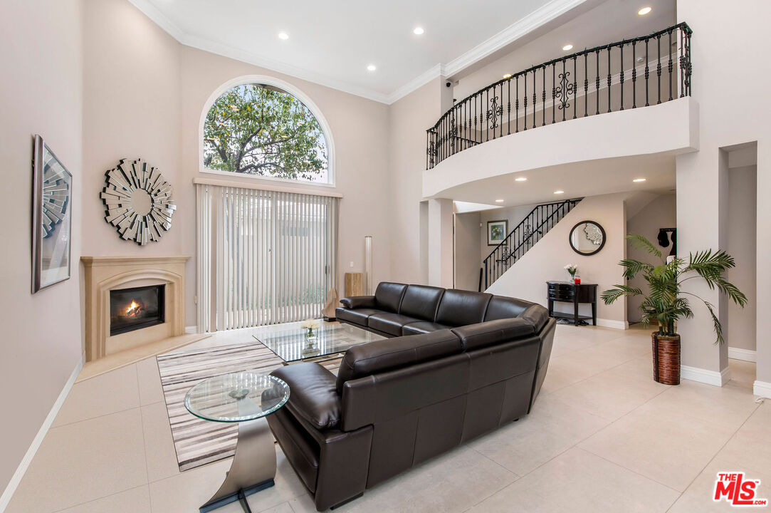 a living room with furniture a fireplace and a potted plant