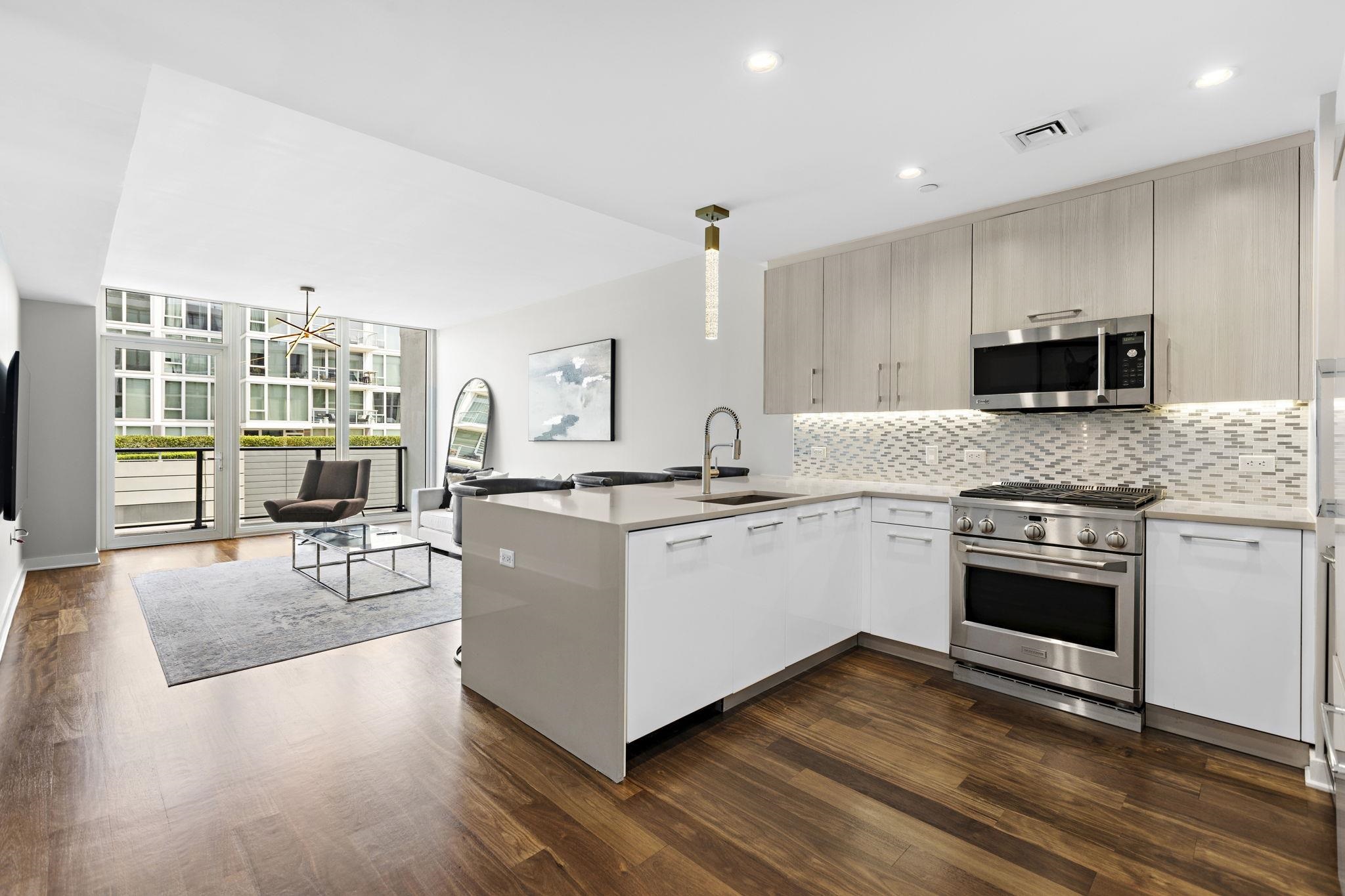 a kitchen with kitchen island granite countertop wooden floors and stainless steel appliances