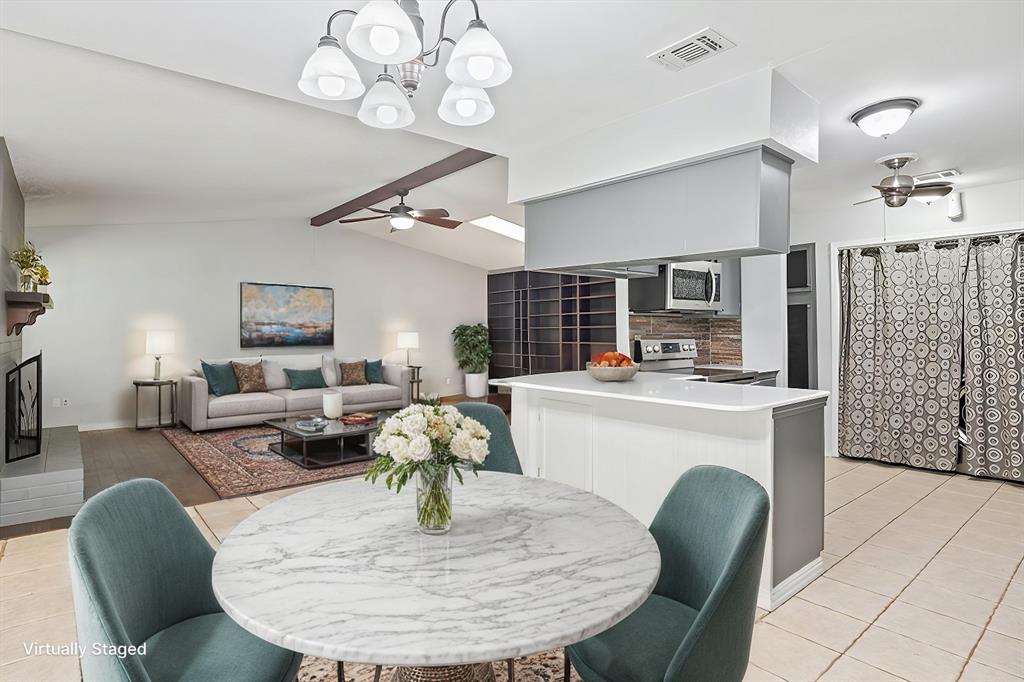 a living room with furniture a fireplace and kitchen view