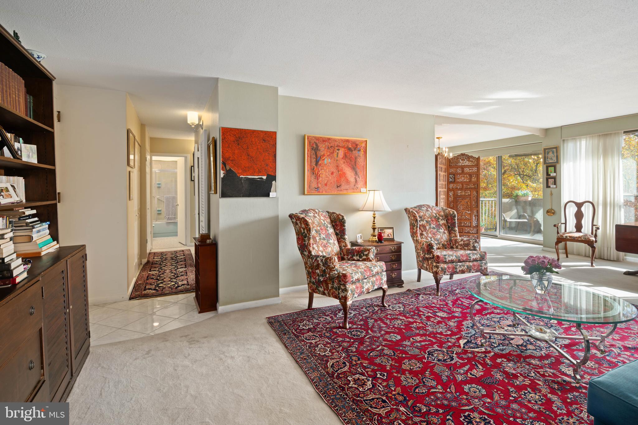 a living room with furniture a rug and a large window