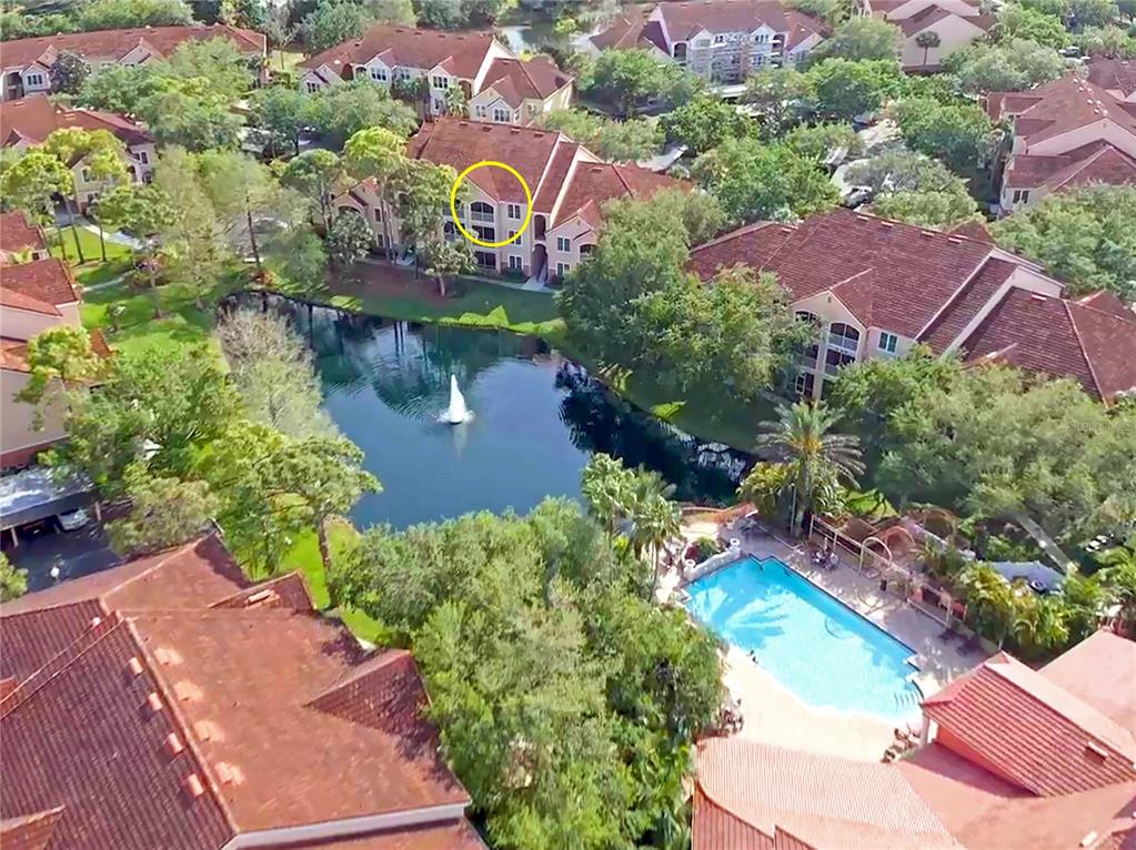 an aerial view of a house with a garden and lake view