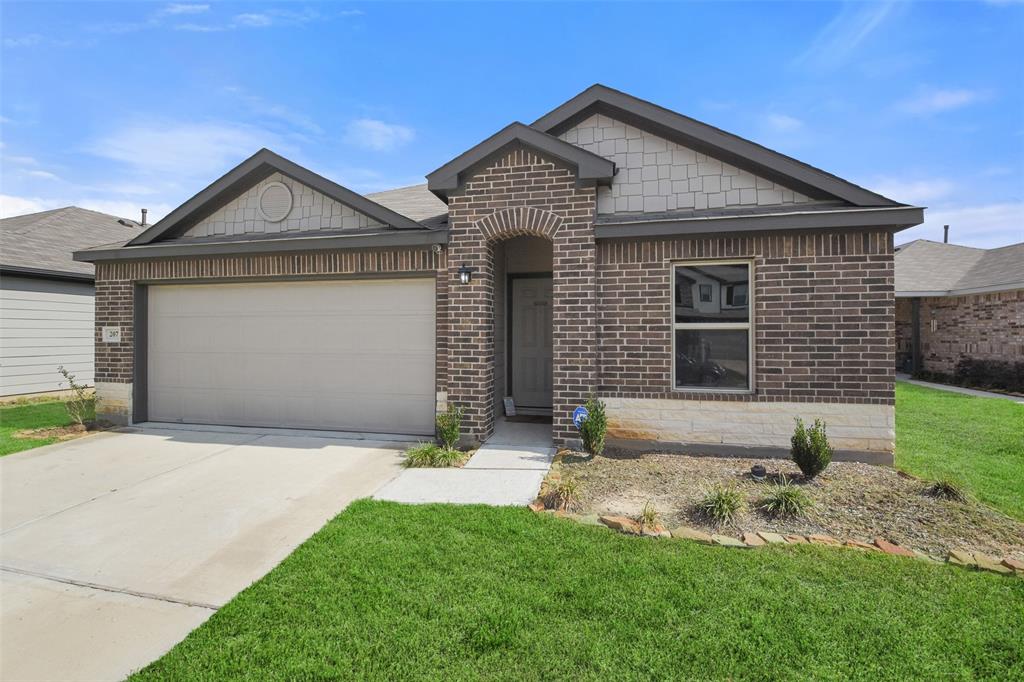 a front view of a house with a yard and garage