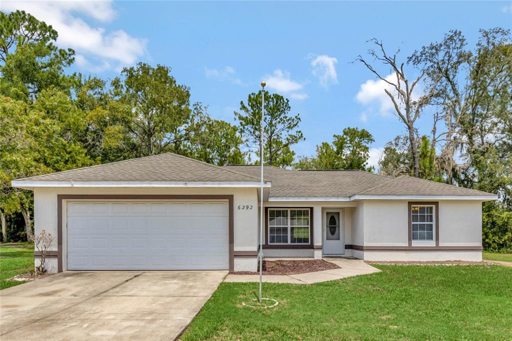 front view of a house with a yard and trees