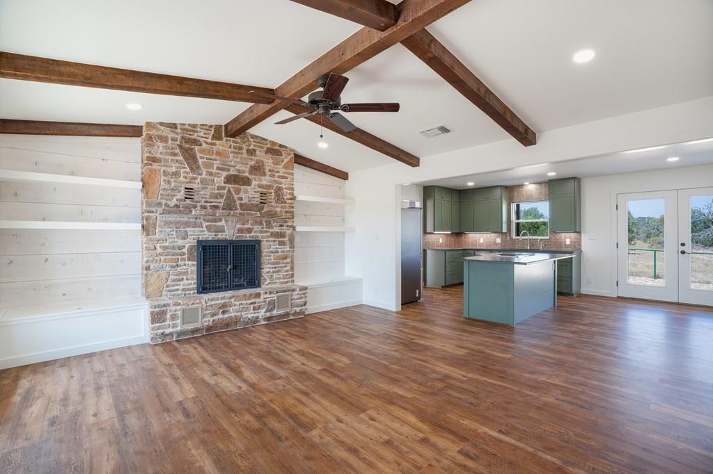 a view of kitchen with granite countertop stainless steel appliances and wooden floor