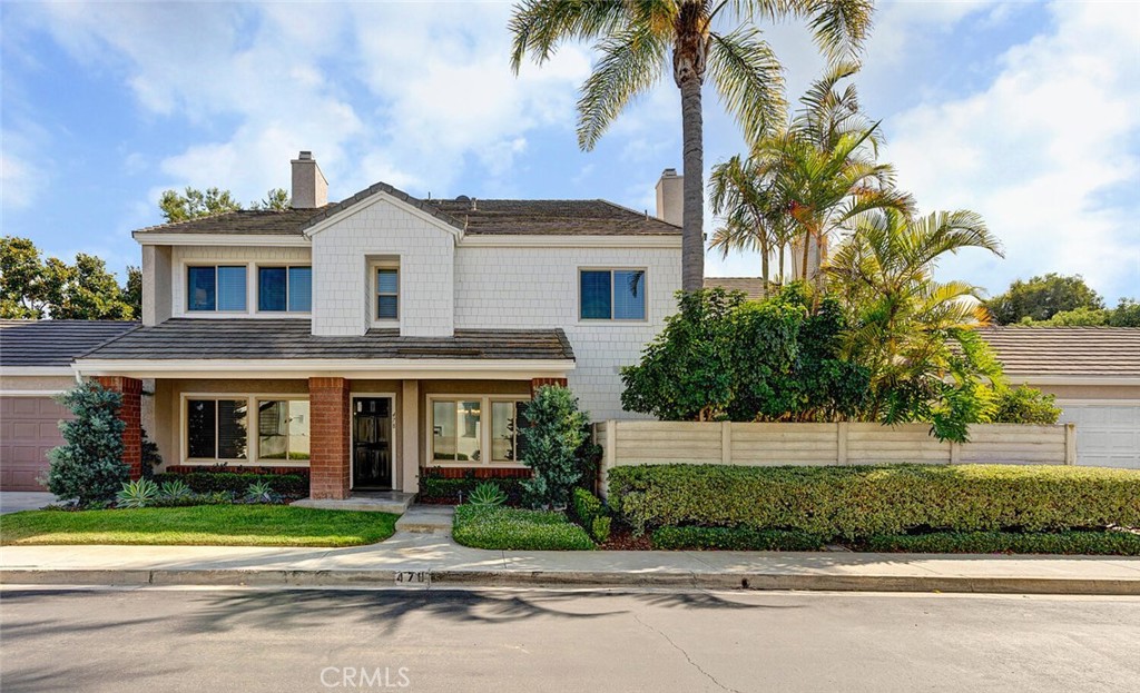 a front view of a house with a yard and potted plants