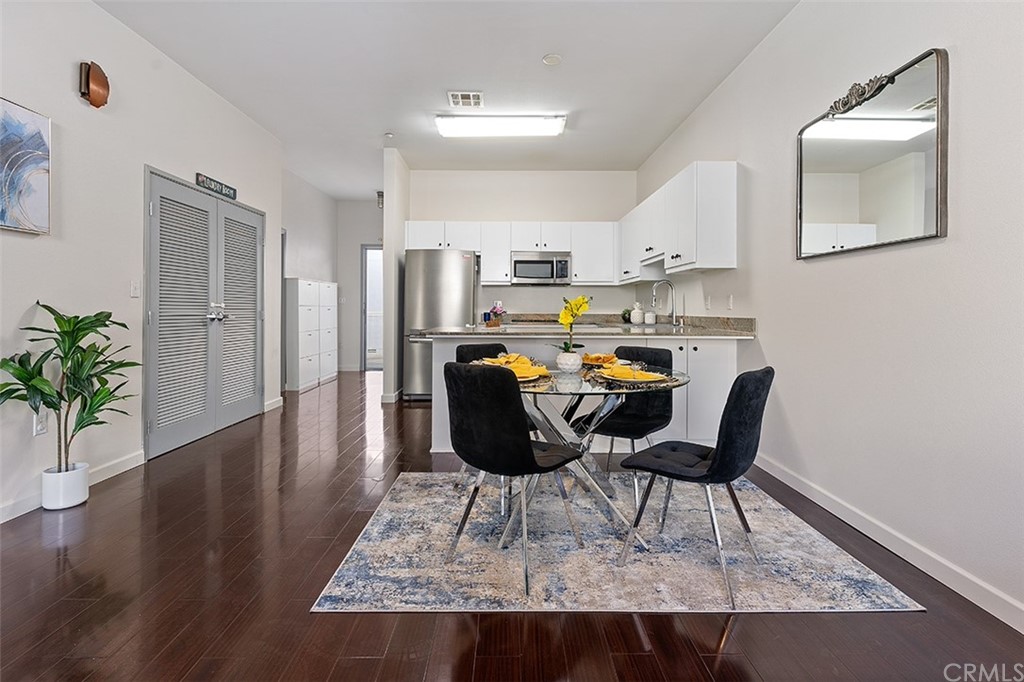 a living room with furniture and a dining table with wooden floor