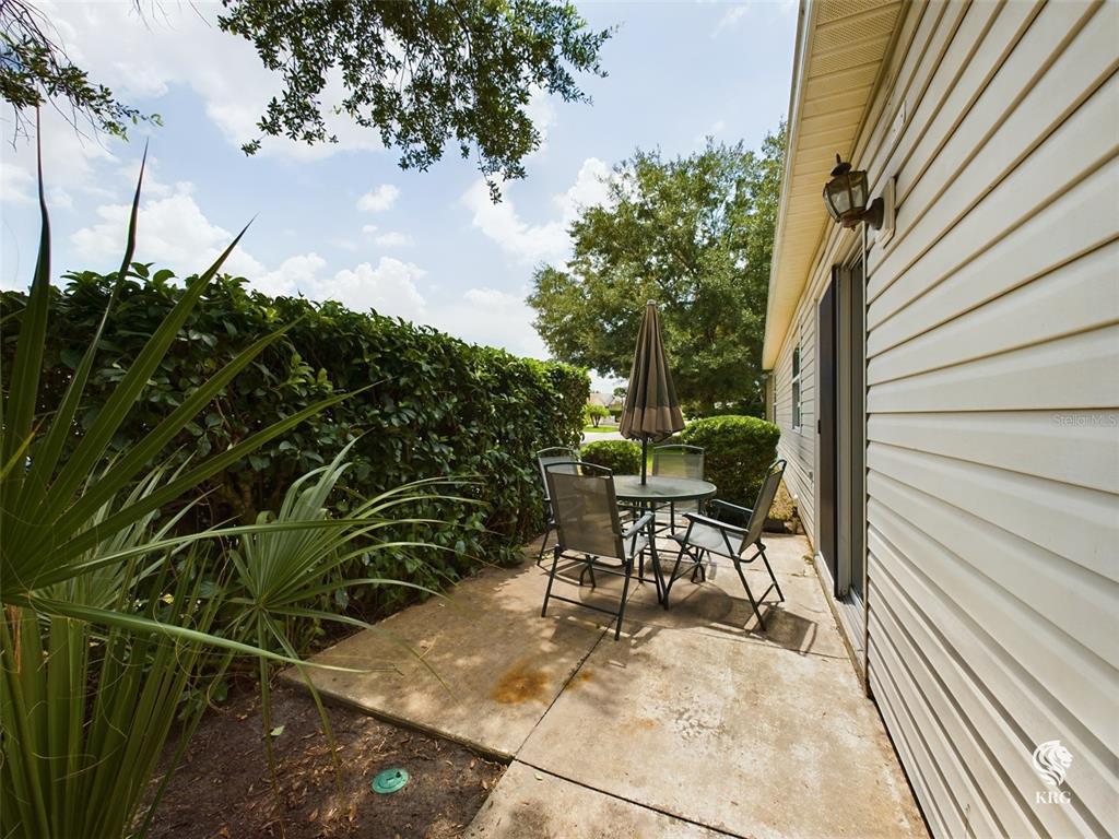 a view of a patio with table and chairs and potted plants with wooden floor and fence