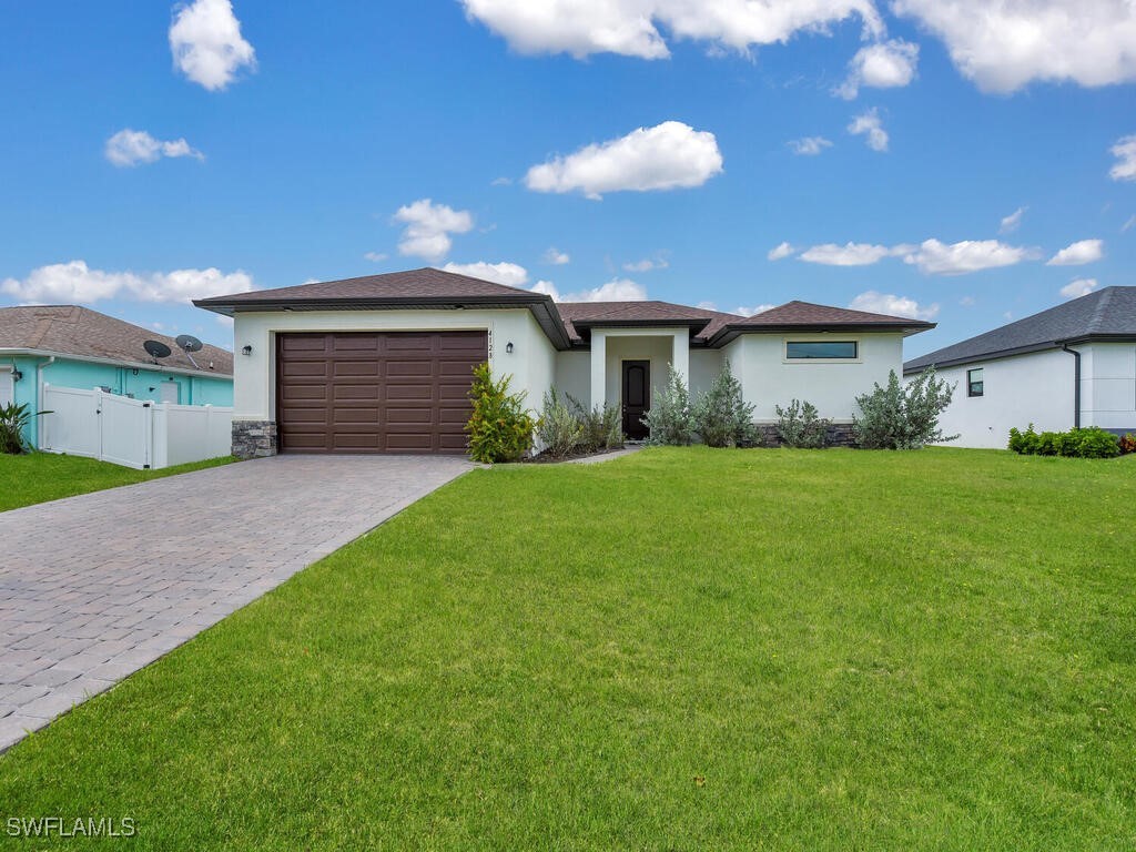 a backyard of a house with plants and large tree