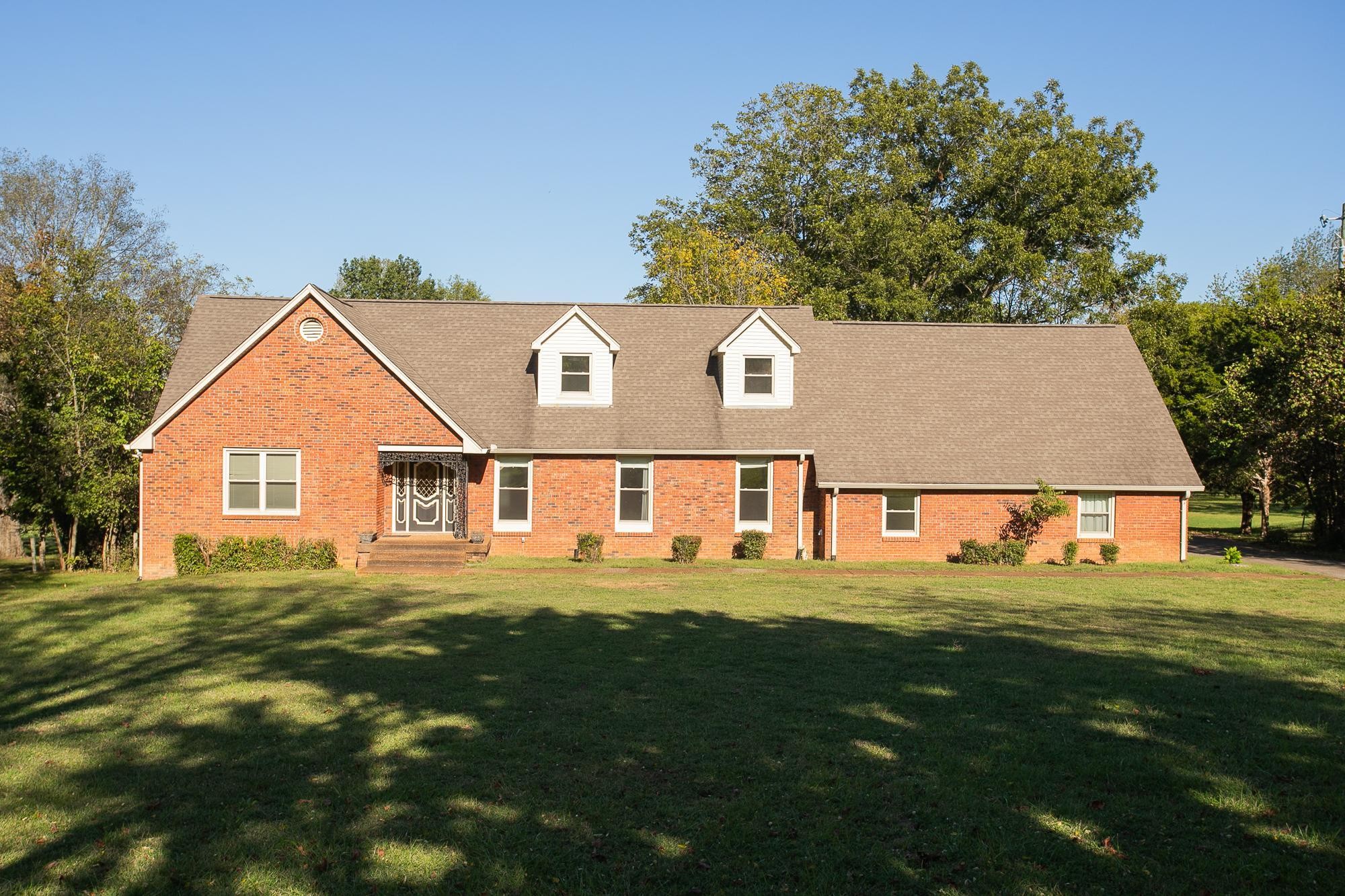 a view of house with outdoor space and garden