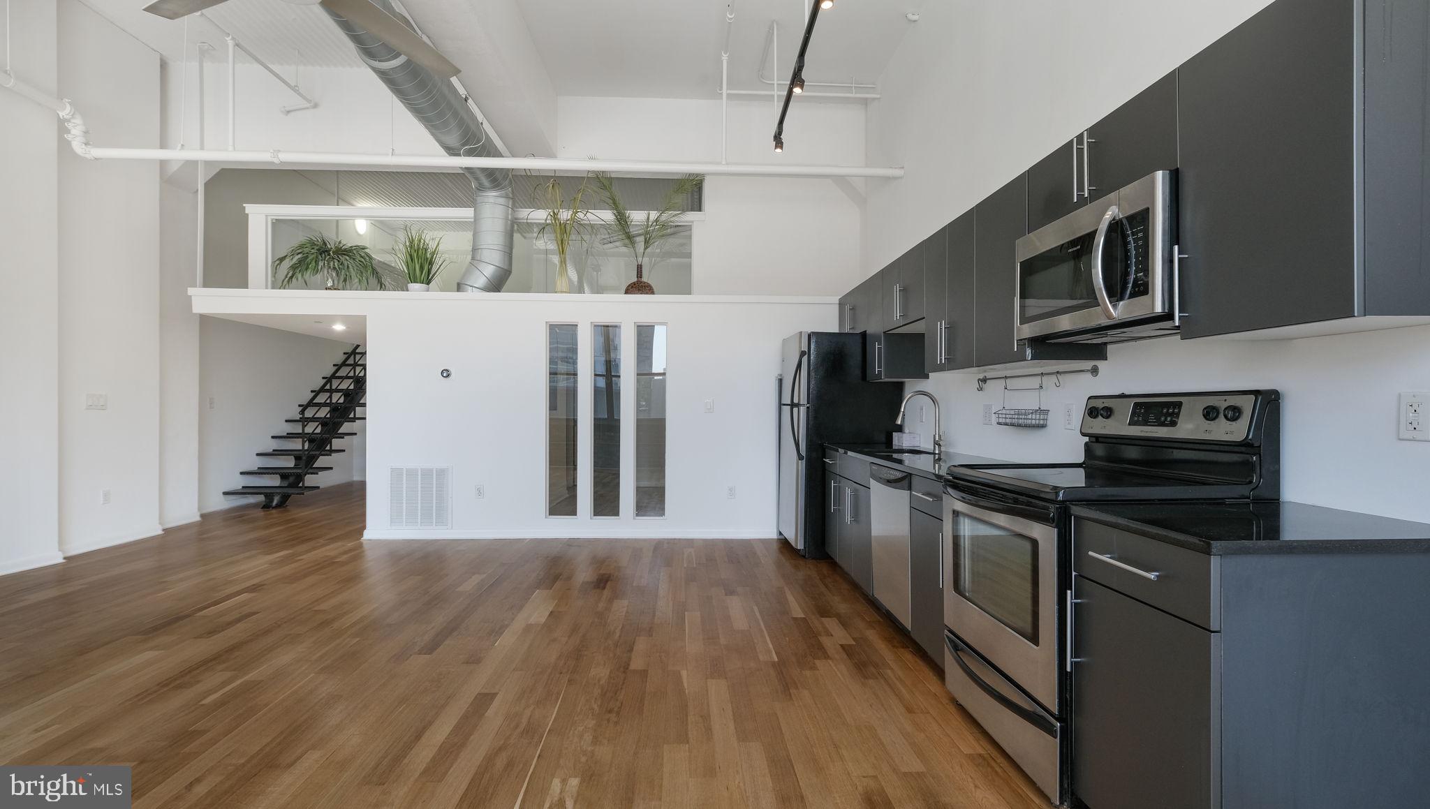 a kitchen with stainless steel appliances and wooden floor