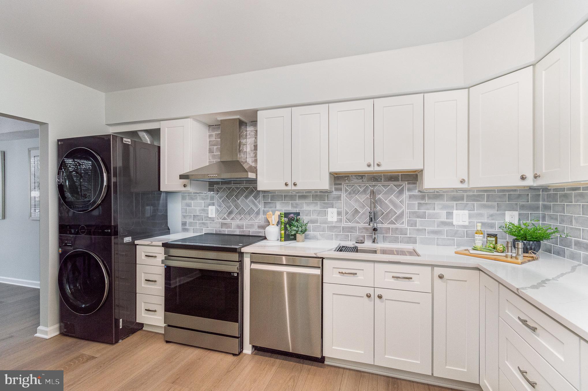 a kitchen with white cabinets and stainless steel appliances