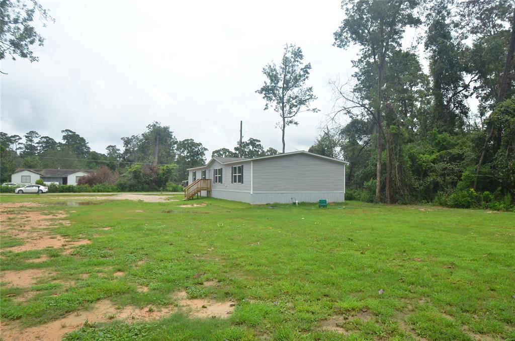 a backyard of a house with lots of green space and lake view in back